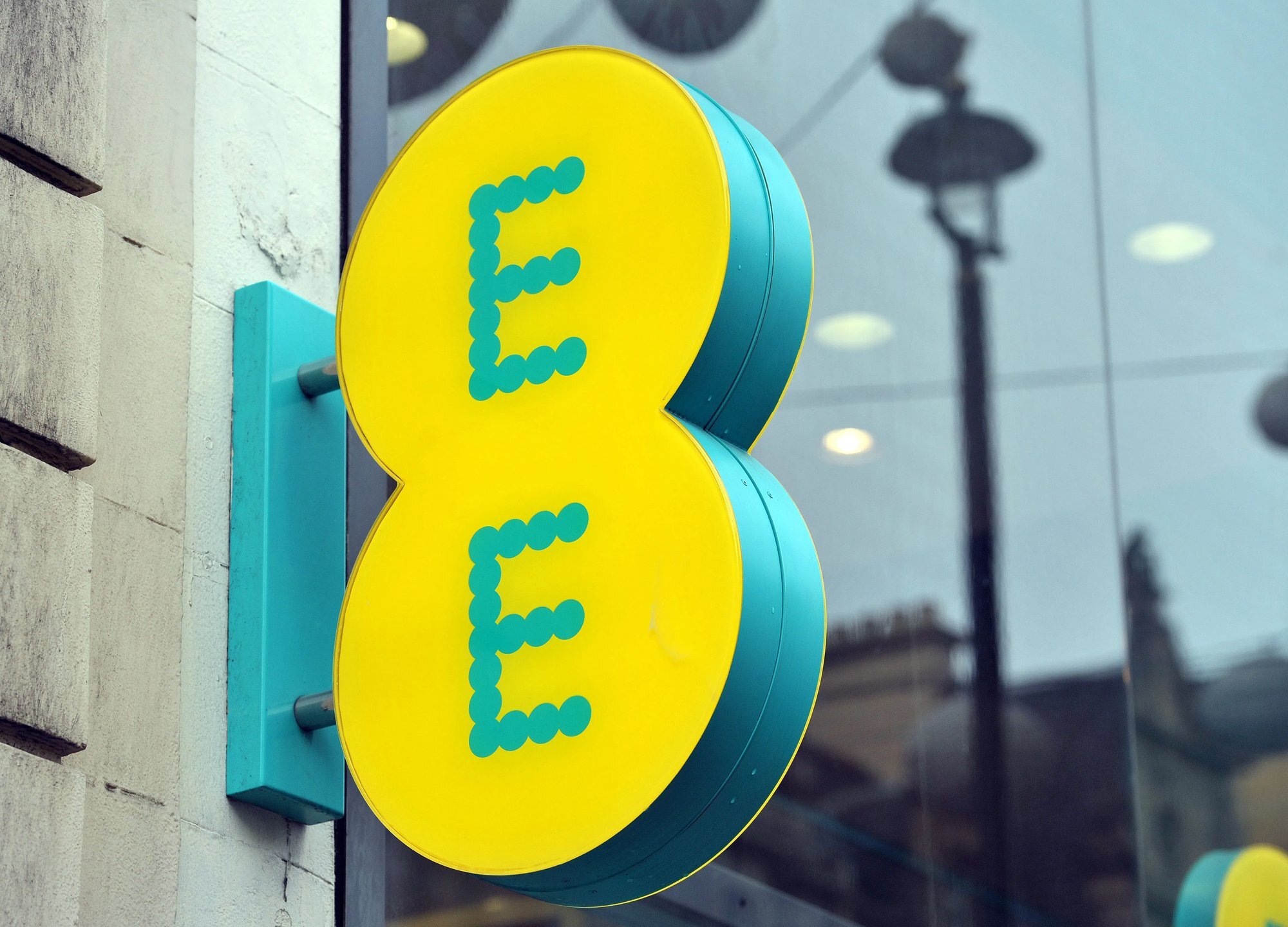 Close-up of the EE roundel fascia sign mounted on a shopfront exterior