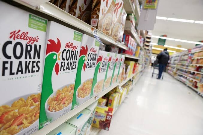 Kellogg's Corn Flakes boxes displayed on a supermarket shelf