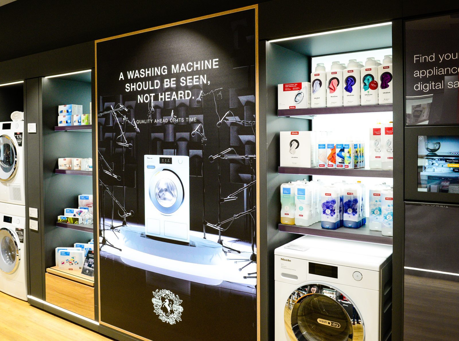 Miele 'A washing machine should be seen, not heard' campaign wall display with washing machine on a lit plinth