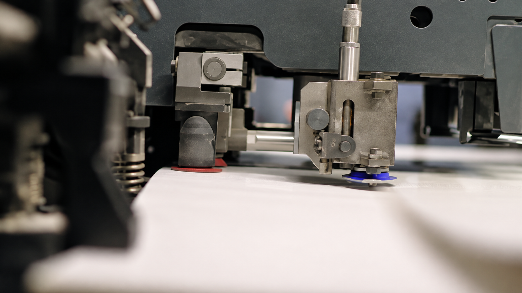 Close-up of a machine head working on a printed sheet