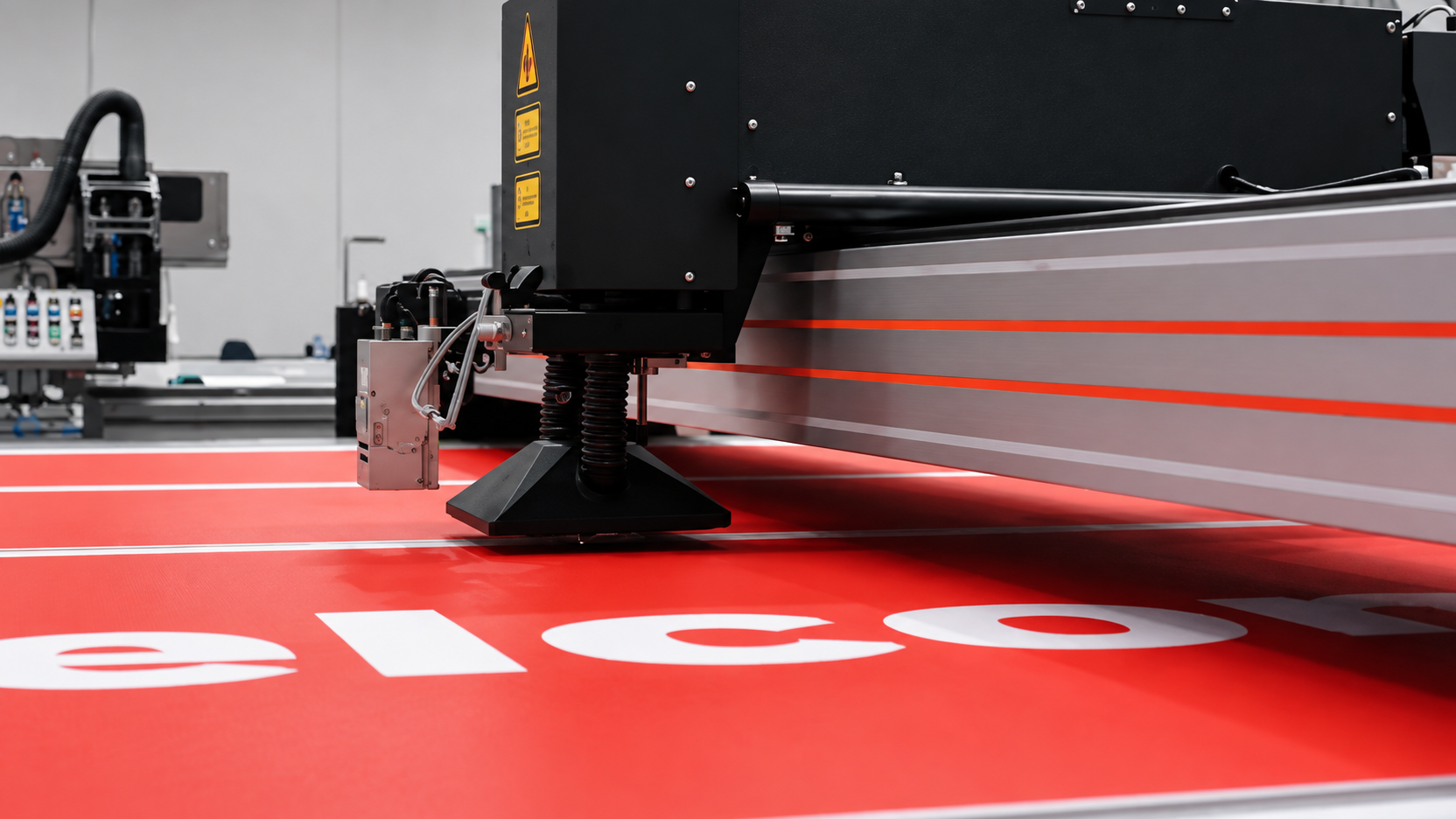 Large-format printer running across a red printed panel