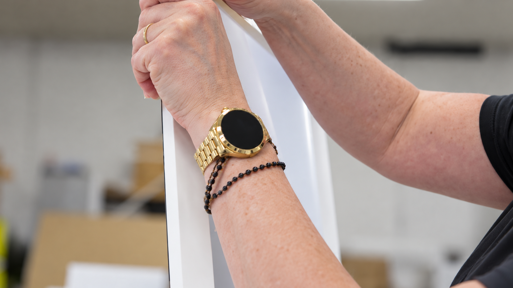 Hands fitting an edge frame to a display unit